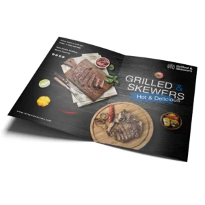 Restaurant menus printing Singapore featuring grilled steak and skewers promotional layout with dark wood background and food photography